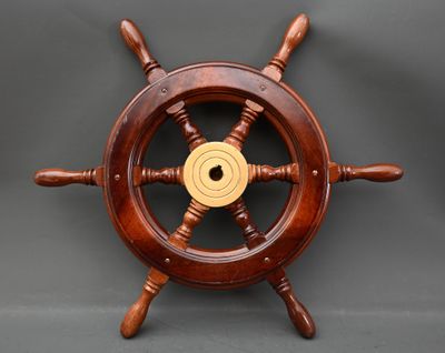 une image représentant une roue de gouvernail en bois avec un centre doré