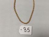 un collier en or sur lequel figure un petit chiffre