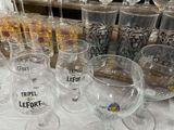 many wine glasses sitting on a table next to each other