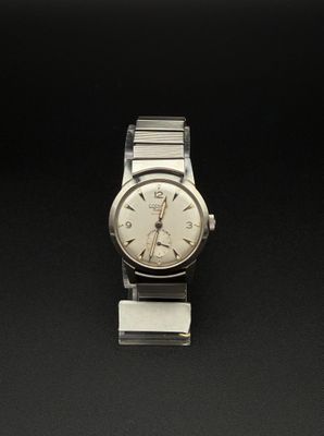 une image représentant une montre argentée posée sur une surface noire