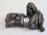 une statue représentant une personne allongée sur une surface blanche