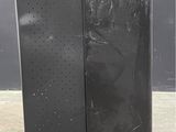 two black speakers are sitting side by side on a concrete floor