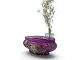 a purple vase with a plant in it on a white surface