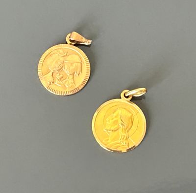 two gold coin pendants with a woman ' s face and a man ' s face on them