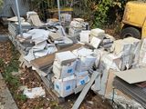 a pile of boxes and boxes sitting on the ground next to a fence