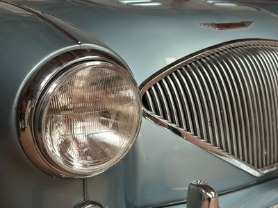 a close up of a car ' s front grill and headlight