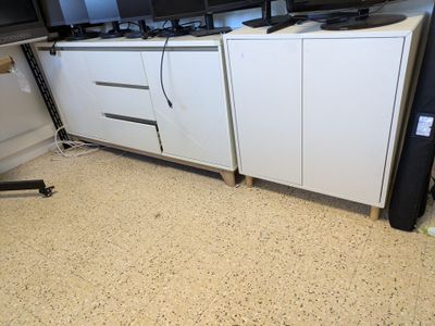 two televisions on a white cabinet in a room