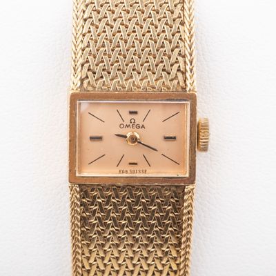 a close up of a gold wrist watch on a white surface