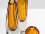 three glass vases that are sitting on a table