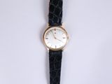 a close up of a watch on a white surface