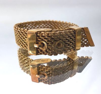 a close up of a gold bracelet on a white surface