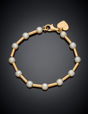 a gold bracelet with pearls and a heart charm