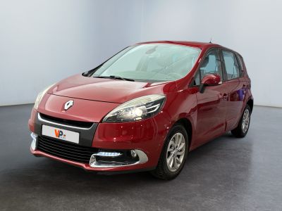 the red car is parked in a large room with a black floor
