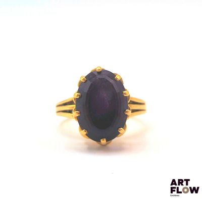 an image of a gold ring with a purple stone in the center