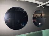 deux miroirs ronds accrochés au mur au-dessus d'un canapé vert