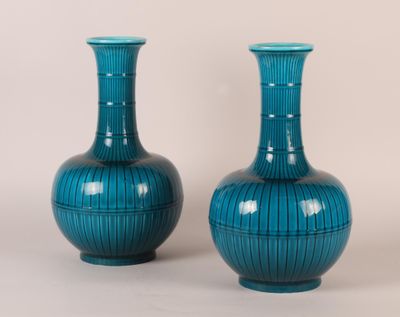 pair of blue vases sitting on a white surface next to each other