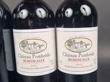 three bottles of red wine are lined up on a table