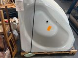 une baignoire blanche posée sur une palette dans un magasin