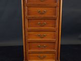 a wooden chest of drawers on a black background
