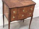 une petite commode en bois posée sur une table