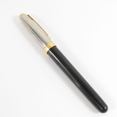 un gros plan d'un stylo sur une surface blanche avec un fond blanc