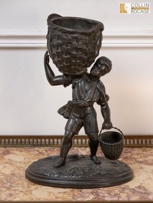 statue en bronze représentant un garçon portant un panier sur la tête