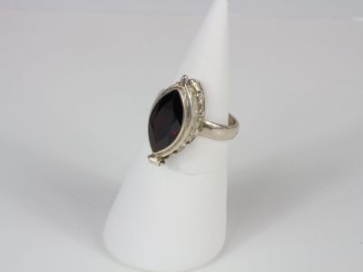 a close up of a silver ring with a black stone