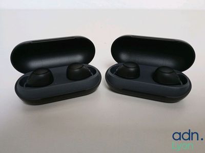 deux écouteurs noirs posés l'un à côté de l'autre sur une table