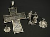 une croix en argent et une médaille sur un fond noir