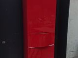 a red refrigerator sitting on a pallet in a room
