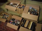 de nombreux cartons remplis de livres posés sur un canapé dans un salon