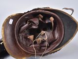 a brown leather hat with a long black hair on it