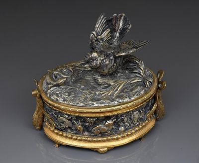 une boîte en argent et en or ornée d'un oiseau