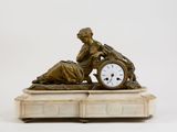 a statue of a woman with a clock on top of a table