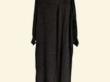 black dress hanging on a hanger against a white wall