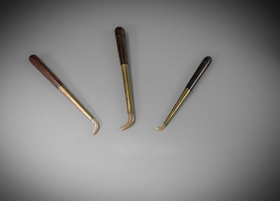 three different types of knitting needles on a white surface
