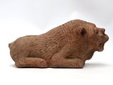 a small statue of a bear sitting on a white surface