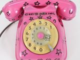 a pink telephone with stars on it on a white surface