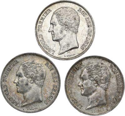 three silver coins, one of which has a head of a man and one of which is a woman