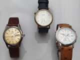 trois montres sont présentées sur une surface blanche avec un fond blanc