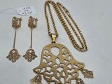 a gold necklace and earring set with a bird pendant