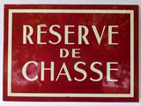 red and white sign on a wall saying reserve de chasse