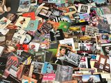 une pile de magazines par terre, à côté d'un ours en peluche