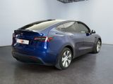 the back of a blue tesla model x parked in a garage