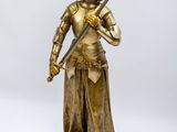 une statue représentant une femme tenant une épée, sur fond blanc