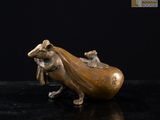 figurine en bronze représentant une souris à longue queue posée sur un fond noir