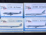 trois boîtes contenant des maquettes d'avions sur fond noir