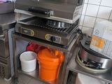 a kitchen with a stove, sink, and pots on the counter