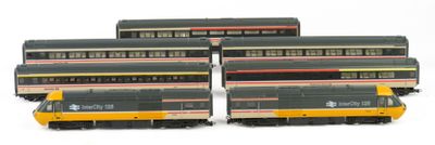 four model trains are lined up in a row on a white surface