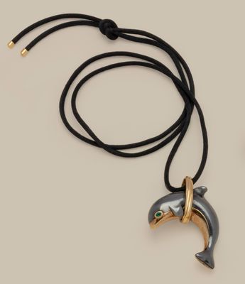 a close up of a necklace with a dolphin on it